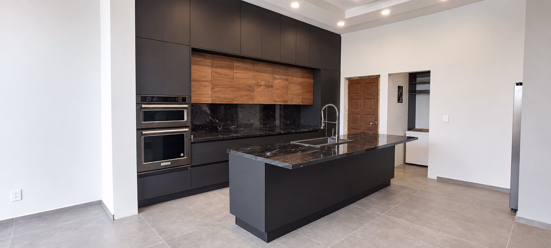 Cocina a medida de Olivewood con isla de frentes oscuros y gabinetes en madera
